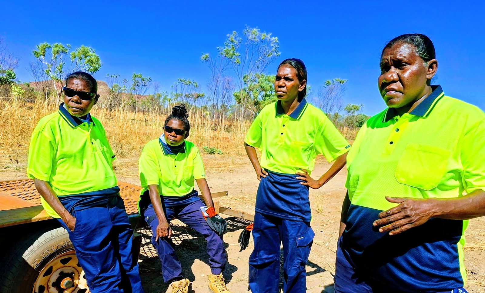 Four workers wearing high-visibility shirts